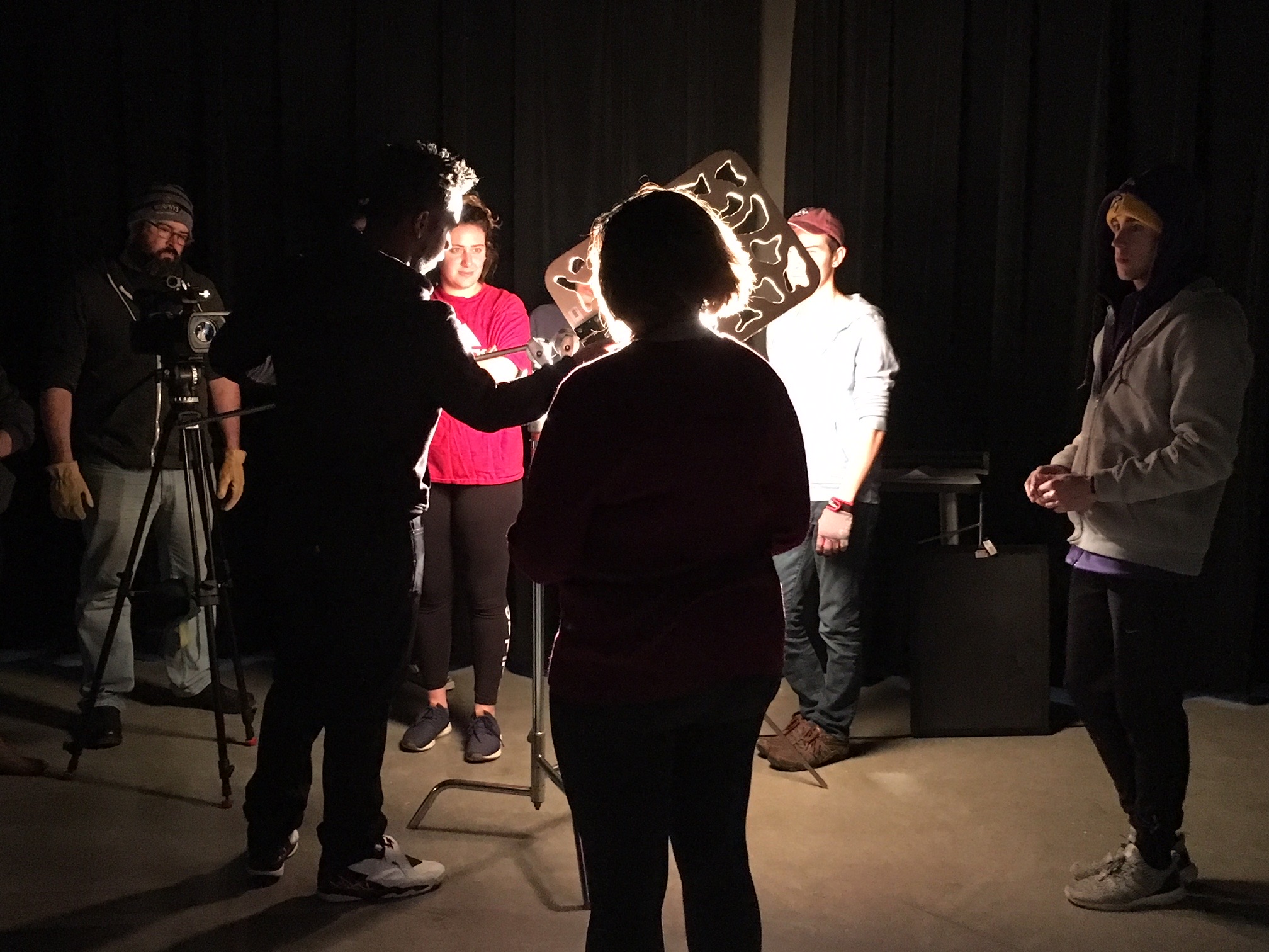 Students film in the darkened production classroom.