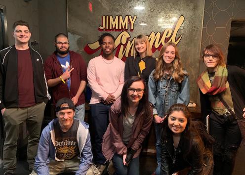 A group of students pose in front of a sign for the Jimmy Kimmel Live! show.
