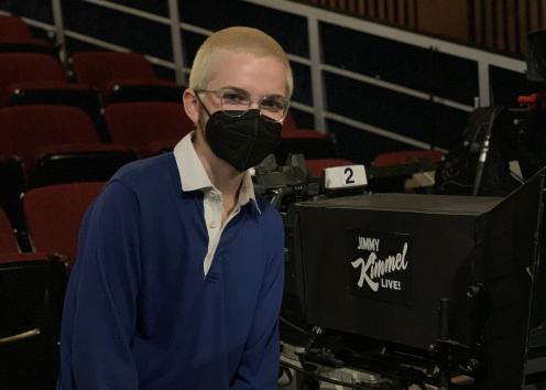 A man stands next to a large camera with "Jimmy Kimmel Live!" written on it.