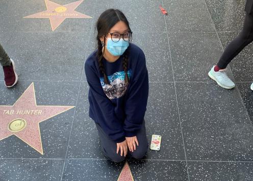 A girl sits in front of a Hollywood star with the name "Steve Irwin" on it.